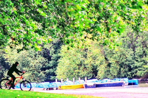 'Gone Fishing' - a silhouette of a boy riding a bicycle holding a stick near the pedlos in Barking Park