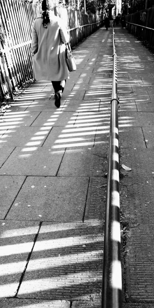 A view down the steep slope to the station entrance with one passenger walking by