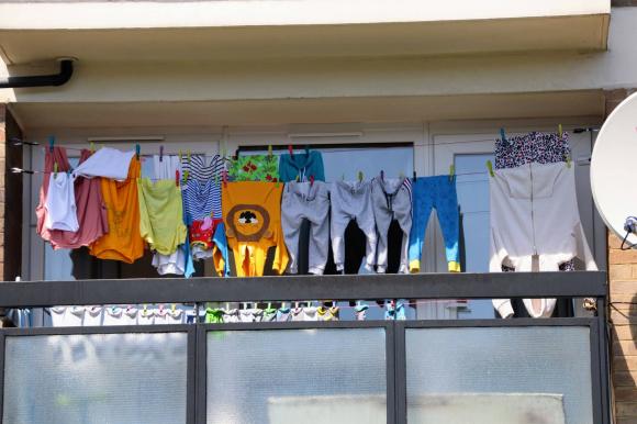An array of colourful washing on a balcany of a high rise tower block