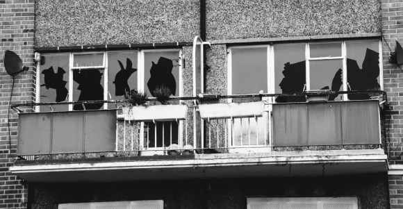 A picture of a vandalised first floor balconied flat representative of all the houses in a large estate