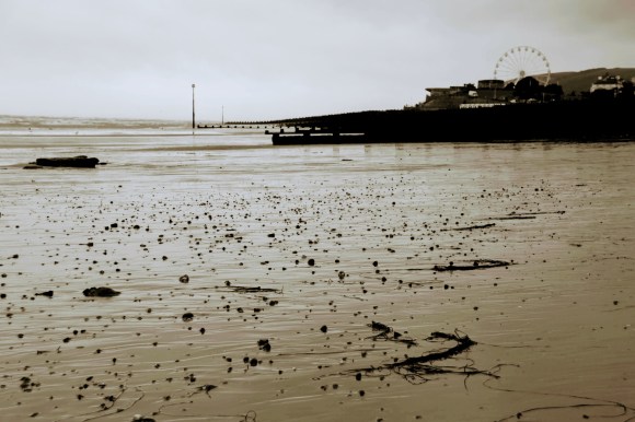 a sepia toned black and white picture of eastbourne shoreline as the tide comes in