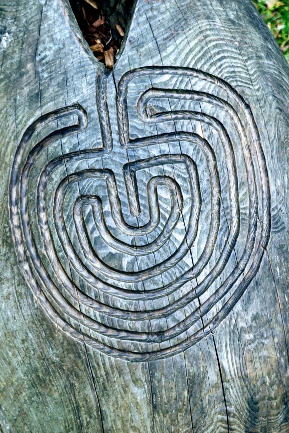 a felled tree with a mystical design carved on its trunk