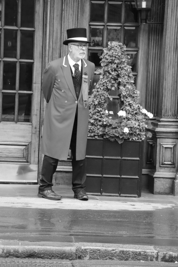 a solitary porter standing patiently outside the 'Rubens at the Park' hotel