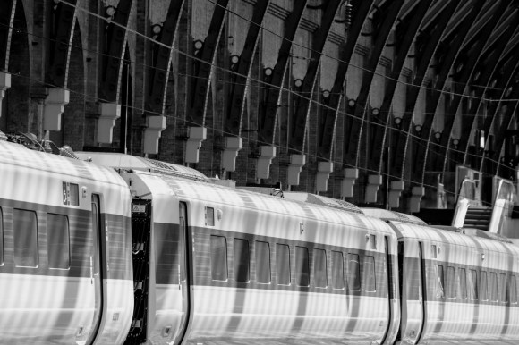 three azuma carriages in the sttaion with a mottleed shadow caused by the sun through the roof
