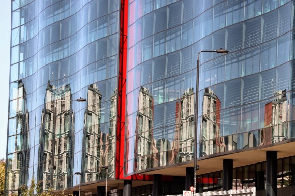 the wavy glass font of Kings pLace with dramatic reflections and a red stripe indicating where two panels meet