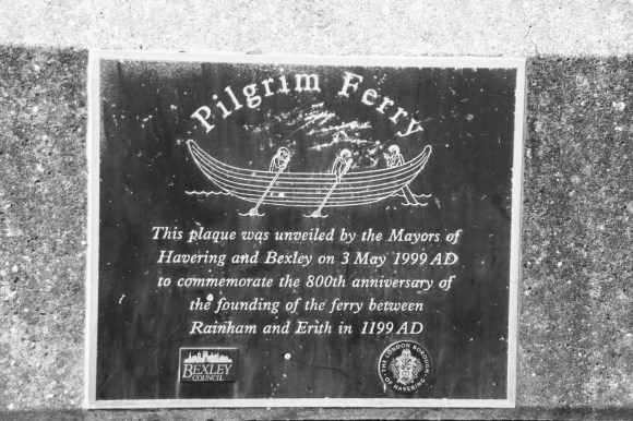 a plaque of three people in a boat rowing with the inscription: 'Pilgrim Ferry' - This plaque was unveiled by the Mayors of Havering and Bexley on 3rd May 1999 AD to commemorate the 800th anniversary of the founding of the ferry between Rainham and Erith in 1199 AD