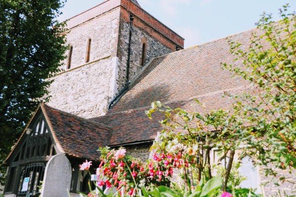 a ground view of the church looking up at the main bell tower and steep roof line