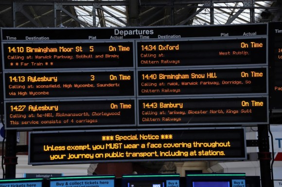 the main display board inside the station showing departures to 6 destinations. There's a Special Notice reminding everyone to wear a facemask