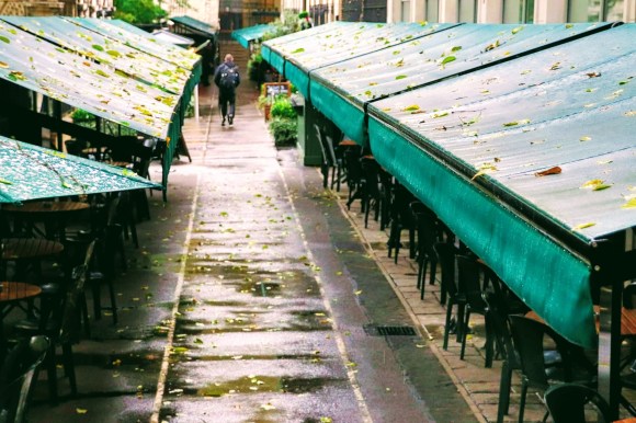 enhanced colour shot along Watergate Walk highlighting the green canpoies of Gordon's Bar flanking a long shot of the damp, leaf strewn empty walkway