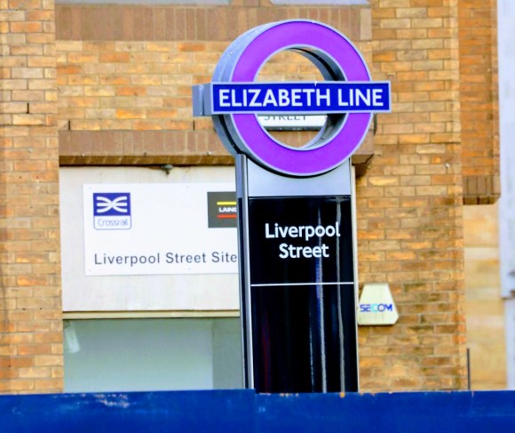 Colour: an Elizabeth Line purple roundel on top of a Liverpool Street sign