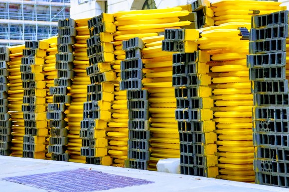Colour: seven columns of yellow plastic barriers about six feet high. The black leg sections of each column creating a stripped effect