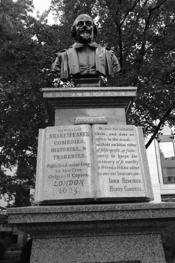 Black & White: the upper section of th memorial plinth topped by a bronse head and shoulder bust of William Shakespear. Underneath, an open book inscribed with a memorial to John Heminges and Henry Condell