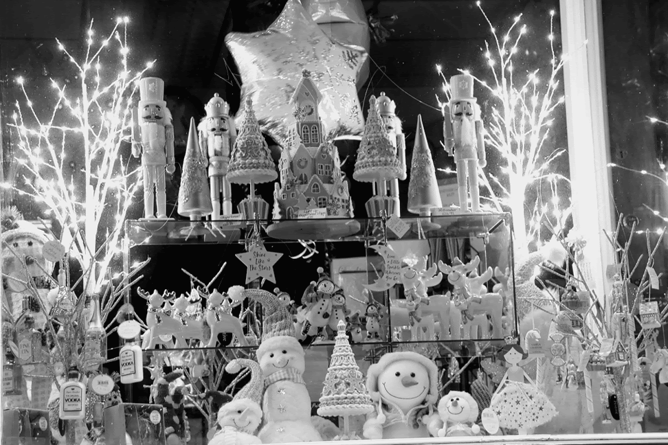 a christmas scene in the shop window with a collection of toy snow people, reindeers and soldiers